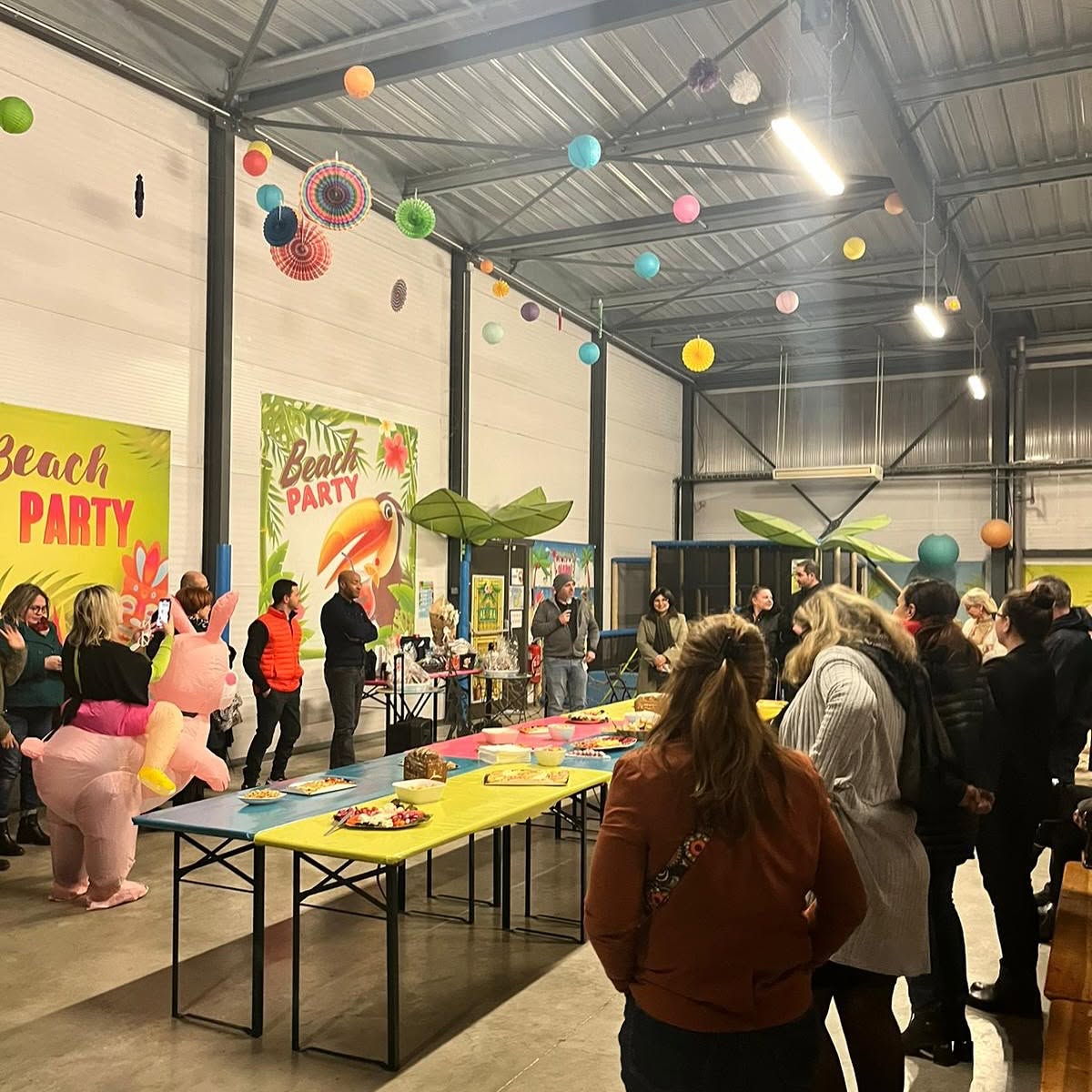 Beach party tropicale aloha dans un espace industriel à Bordeaux avec buffet, décorations colorées et invités déguisés