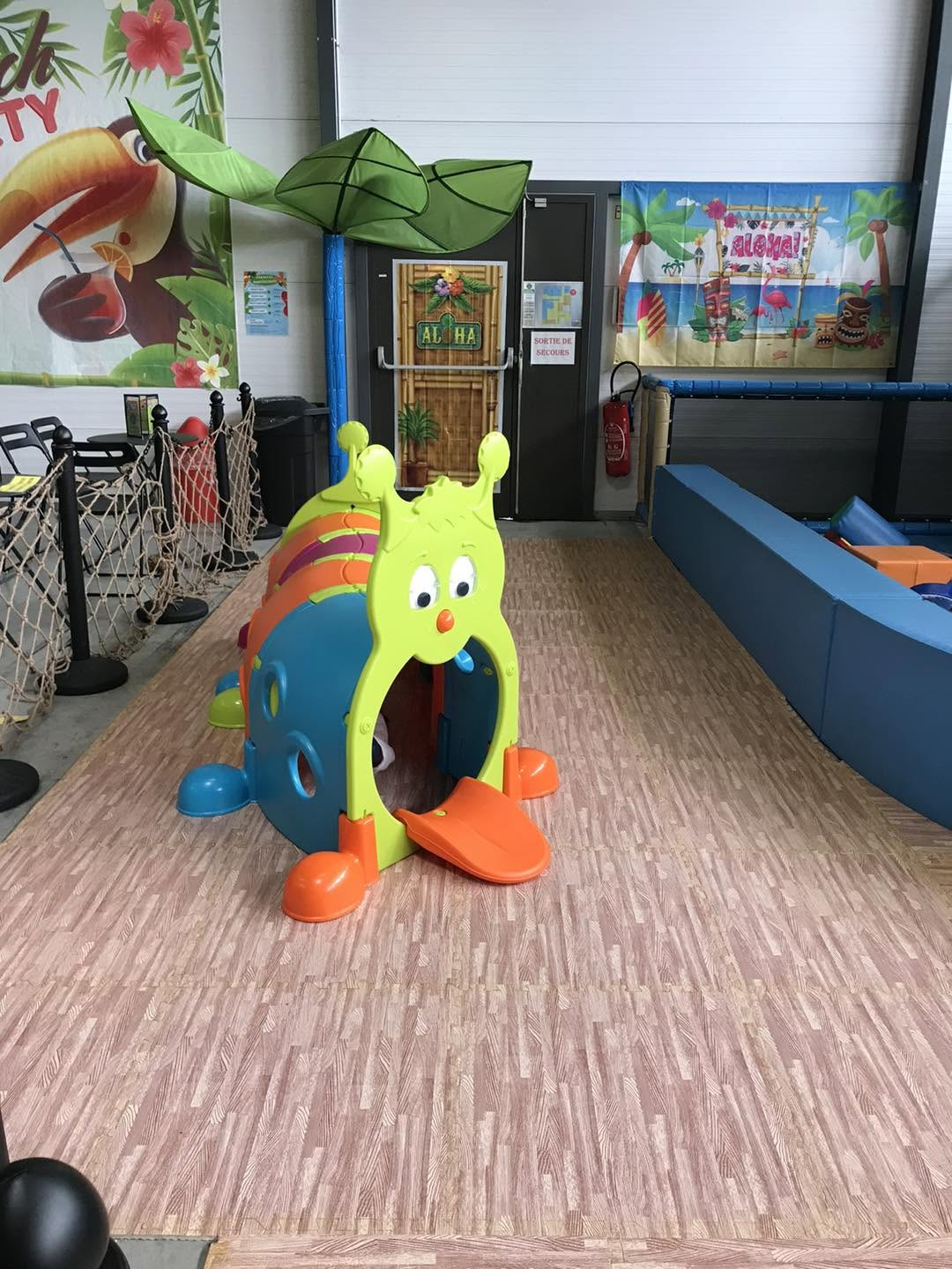 Aire de jeux tropicale aloha à Bordeaux avec tunnel chenille coloré et décor exotique pour enfants