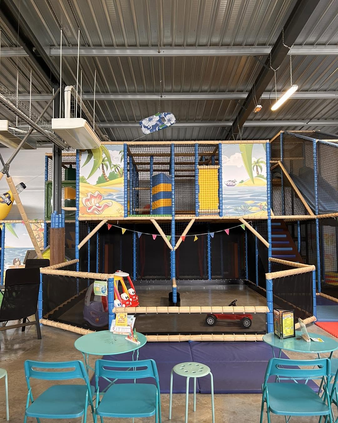 aire de jeux tropicale aloha à bordeaux avec structures en mousse, toboggan et tables enfantines