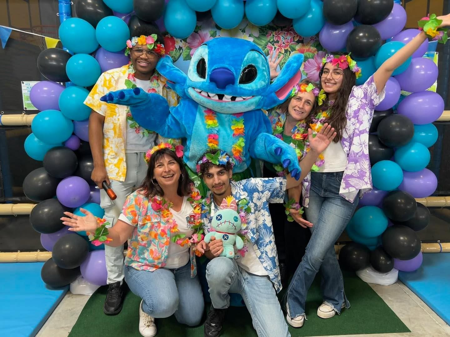 Groupe en chemises hawaïennes avec mascotte Stitch lors d’une fête à thème chez aloha à bordeaux