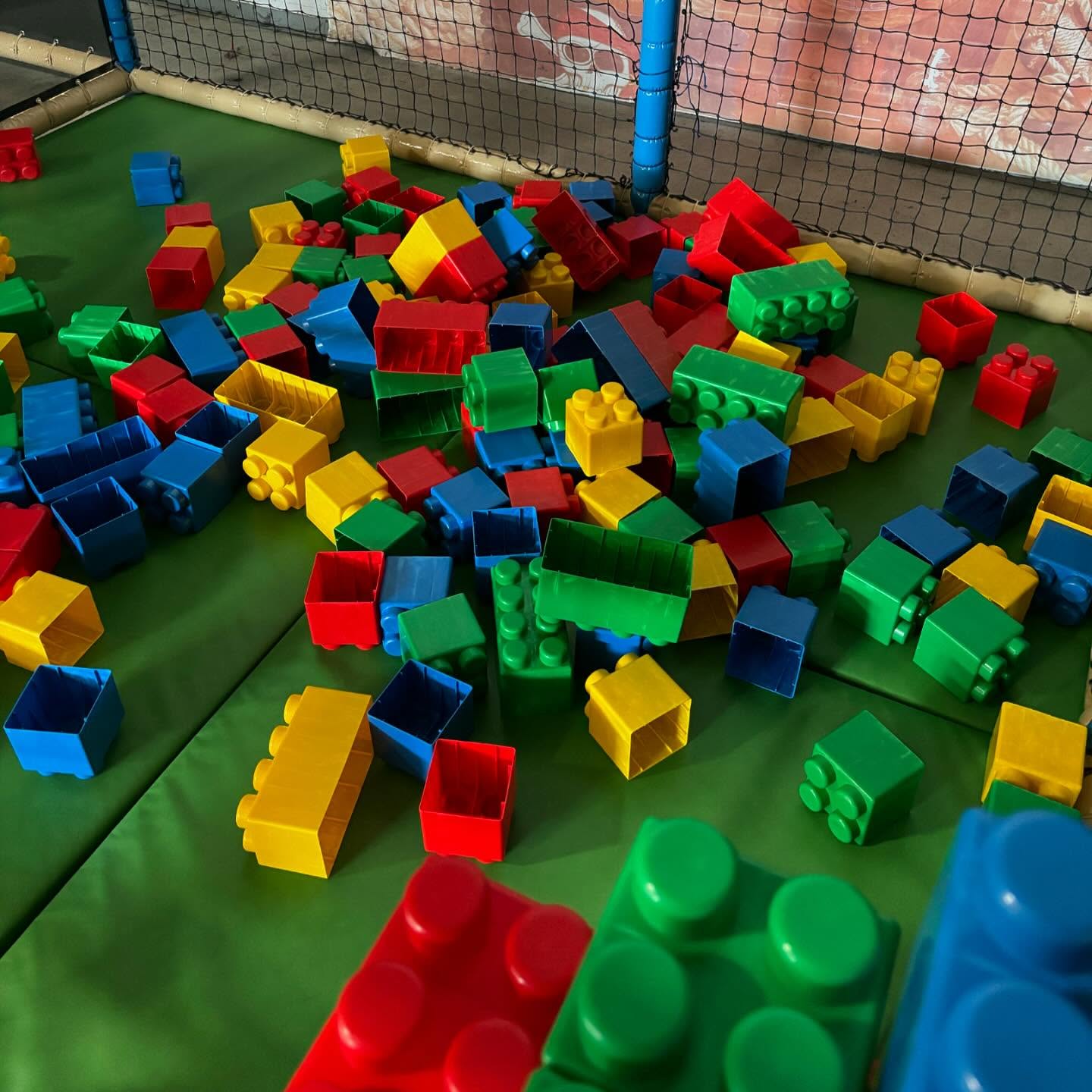 Espace de jeux aloha à Bordeaux avec gros blocs de construction colorés sur tapis vert