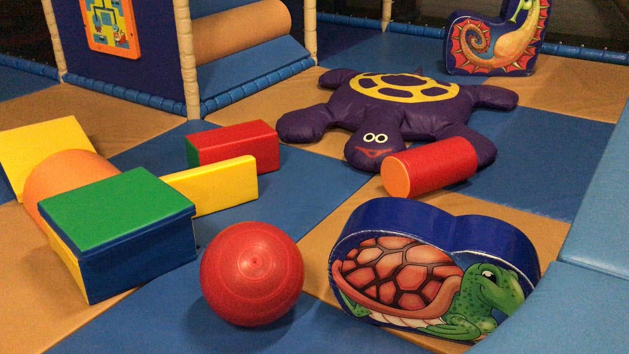 aire de jeux aloha à bordeaux avec modules en mousse colorés et grande tortue violette souriante