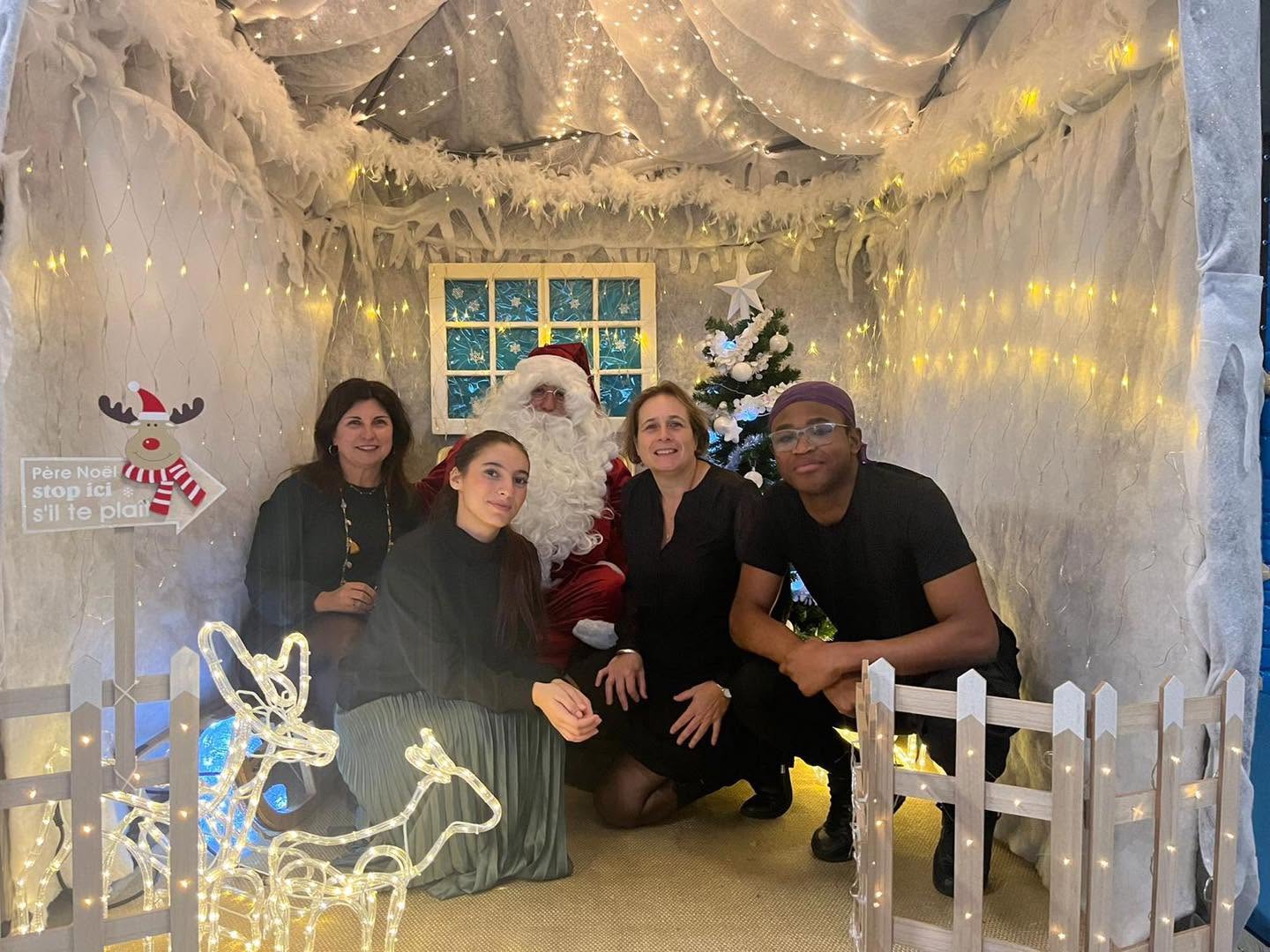 Famille avec Père Noël dans décor féerique de Noël aloha à bordeaux
