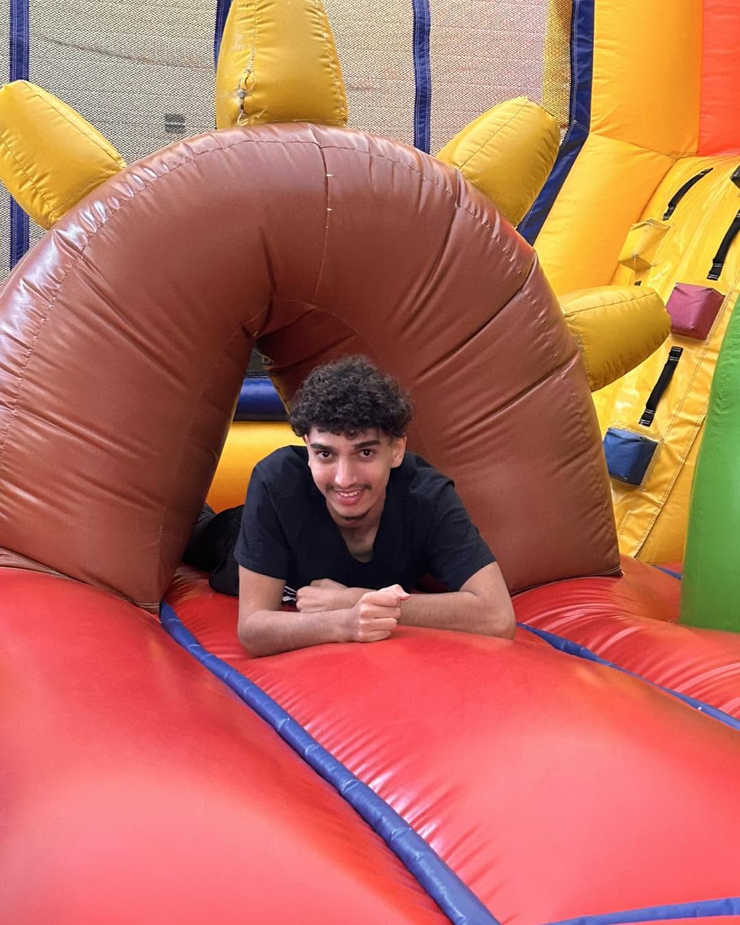 Jeune homme souriant sur structure gonflable colorée chez aloha parc de jeux enfants à bordeaux