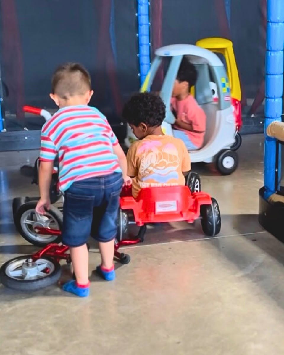 Enfants jouant sur tricycles et voiturettes chez aloha parc de jeux enfants à bordeaux