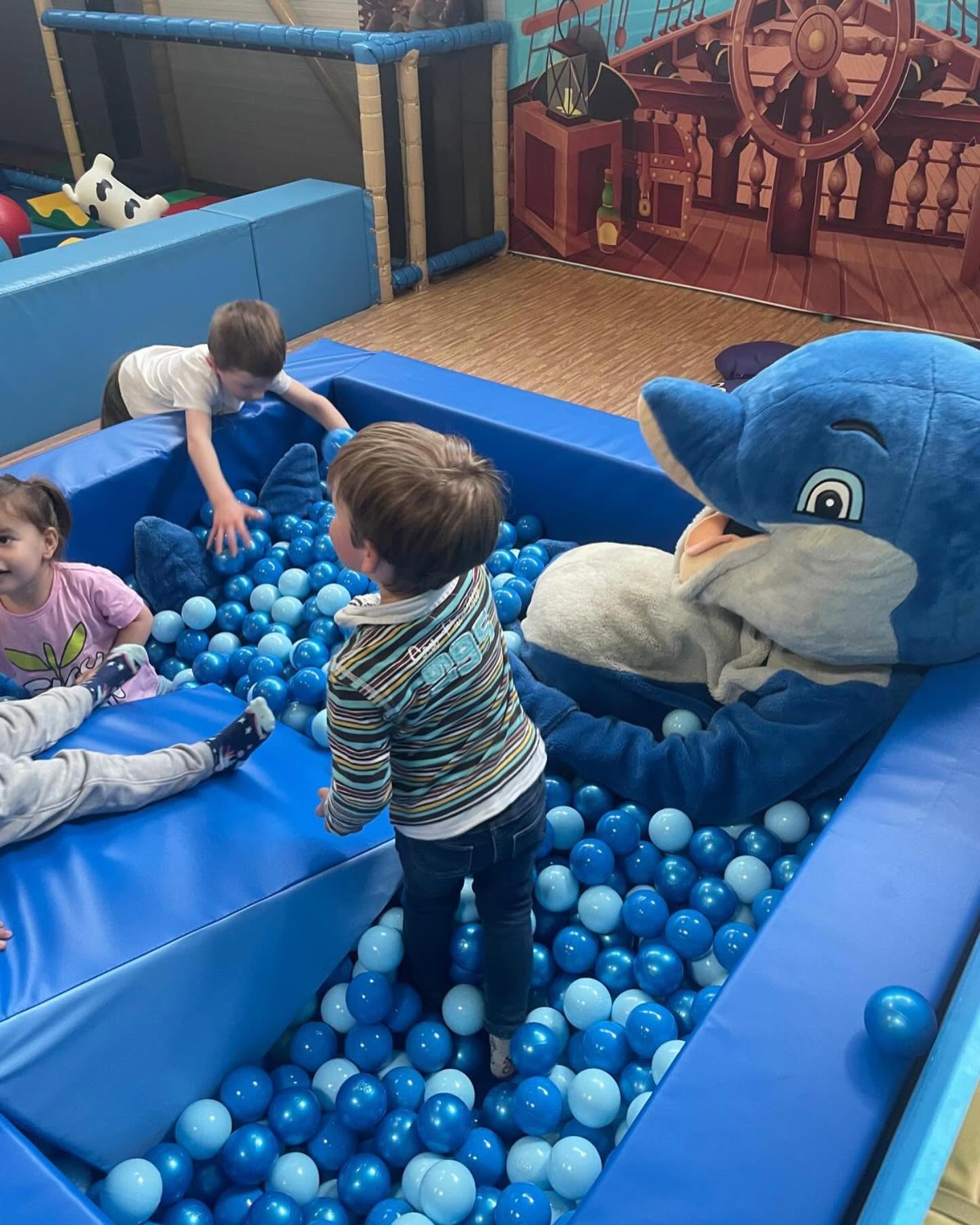 Enfants qui jouent avec une mascotte dauphin dans la piscine à balles aloha à bordeaux
