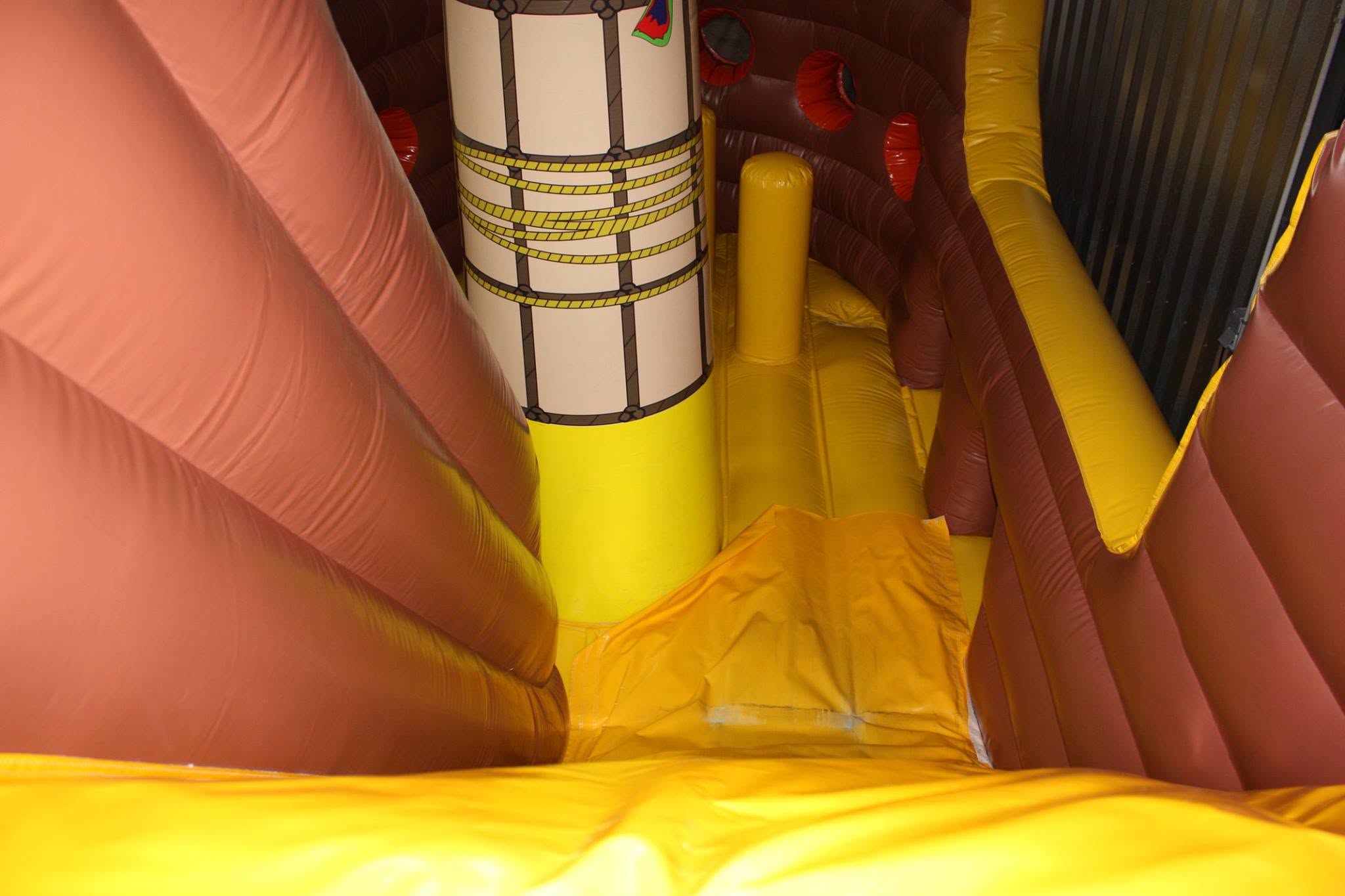 Jeu gonflable thème pirate pour enfants chez aloha à bordeaux, structure sécurisée aux couleurs jaune et marron