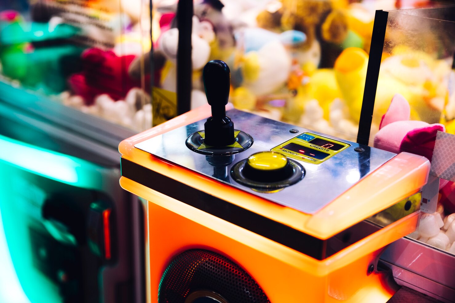 Commande de machine à pince arcade aloha avec joystick et crédits 17 dans une salle de jeux colorée à bordeaux